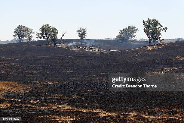 Burnt properties smoulder at Sandhills on January 9, 2013 in Bungendore, Australia. Temperatures cooled overnight offering relief to fire fighters...