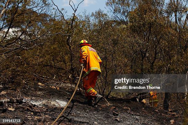 Rural Fire Service members 'mop-up' spot fires at Sandhills on January 9, 2013 in Bungendore, Australia. Temperatures cooled overnight offering...