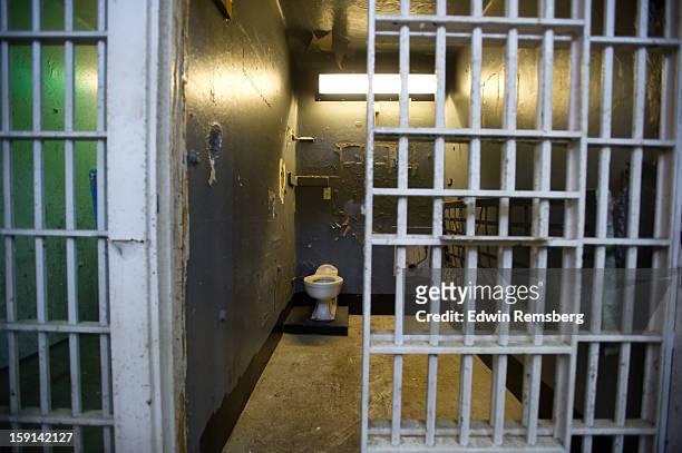 dark empty prison cell - gefängniszelle stock-fotos und bilder