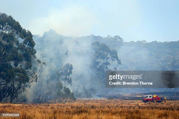Rural Fire Service members attack the fire at Sandhills from the ground on January 9, 2013 in Bungendore, Australia. Temperatures cooled overnight...