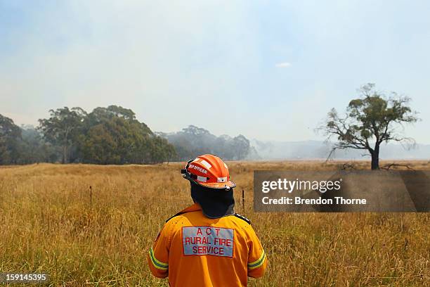 Rural Fire Service member watches water-bombing operations take place on a fire at Sandhills on January 9, 2013 in Bungendore, Australia....