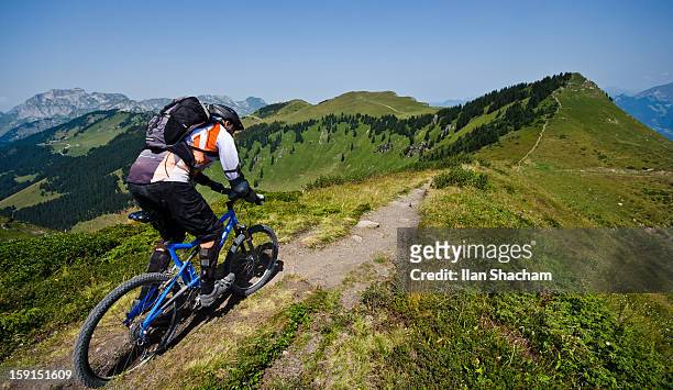mountain biker going down the ridge in the alps - gebirgskamm stock-fotos und bilder