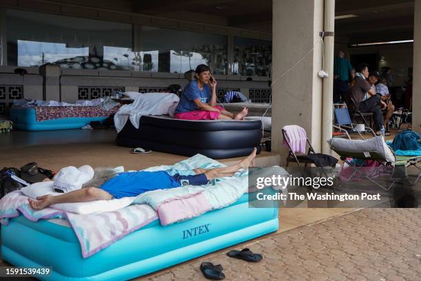 Puong Sui, center, talks to her daughter at War Memorial Stadium in Kahului, Hawaii on August 10, 2023. Sui who lost her house and all belongings in...