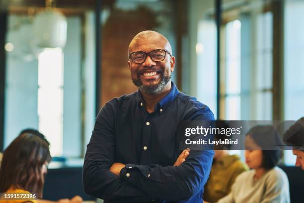 cheerful bearded businessman smiling at camera in office - een dag uit het leven serie stockfoto's en -beelden
