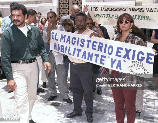 Silent protestors stand infront of the National Congress holding signs criticizing a decision by congress 14 April, 1999 in Caracas. Docentes...