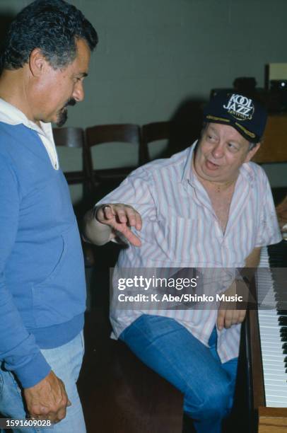 Mel Torme talks to Shorty Rogers in a studio, location unknown, circa 1970s.