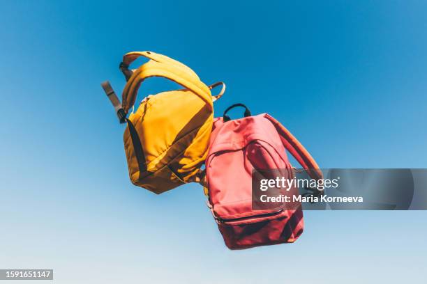 multicolored backpacks on sky background. back to school concept. - beginn des schuljahres stock-fotos und bilder