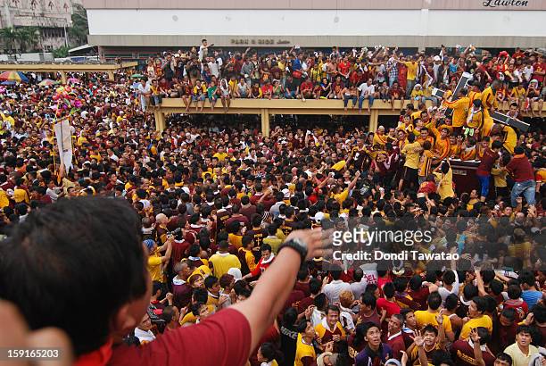 Thousands of Black Nazarene devotees try to climb on the carriage carrying the Black Nazarene during the procession of the 406th feast of The Black...