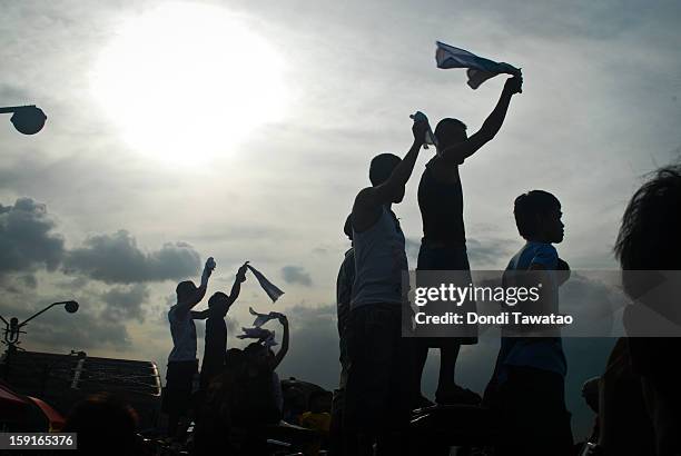 Black Nazarene devotees cheer from rooftops during the 406th feast of The Black Nazarene on January 9, 2013 in Manila, Philippines. Devotees march...