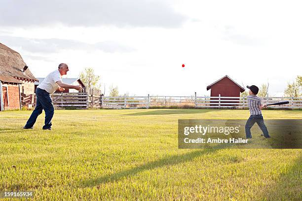 paying baseball with grandpa - baseball tee stock pictures, royalty-free photos & images