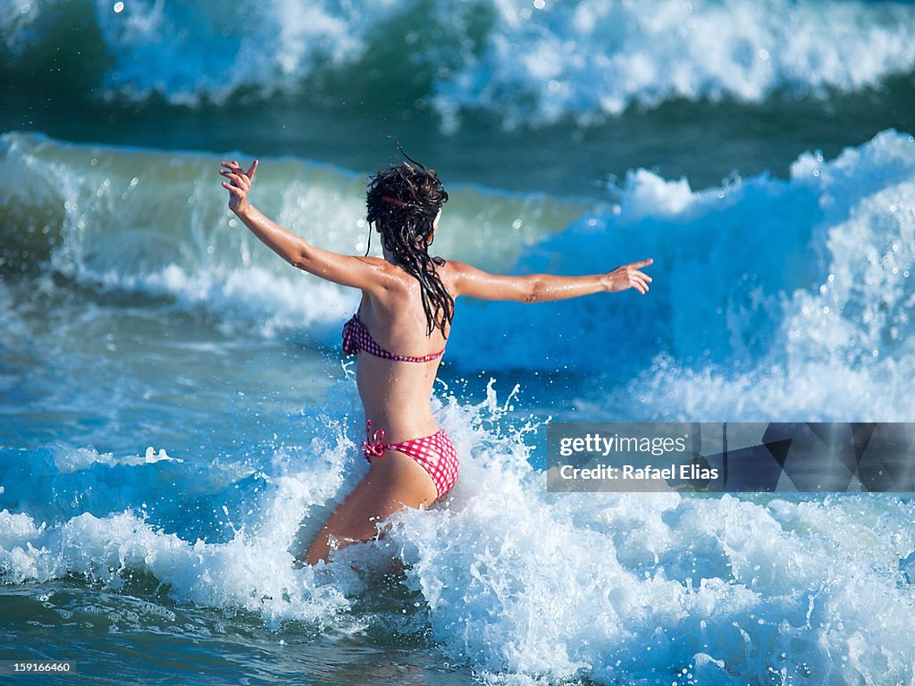 Young woman playing with waves