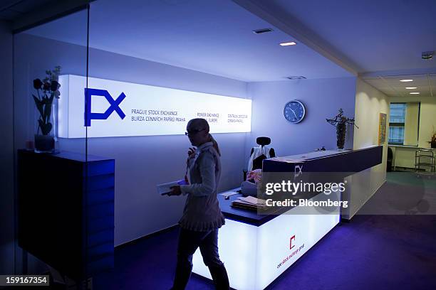 An employee passes an illuminated sign in the reception area of the Prague Stock Exchange in Prague, Czech Republic, on Tuesday, Jan. 8, 2013. The...