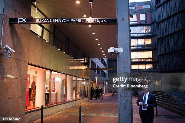 Businessman stands outside the entrance to the Prague Stock Exchange, right, in Prague, Czech Republic, on Tuesday, Jan. 8, 2013. The Czech economy...