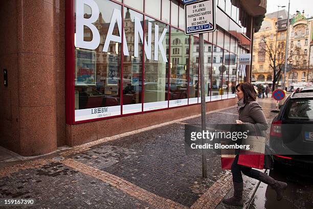 Pedestrian carries shopping bags past a Landesbank Baden-Wuerttemberg, or LBBW, bank branch in Prague, Czech Republic, on Tuesday, Jan. 8, 2013. The...