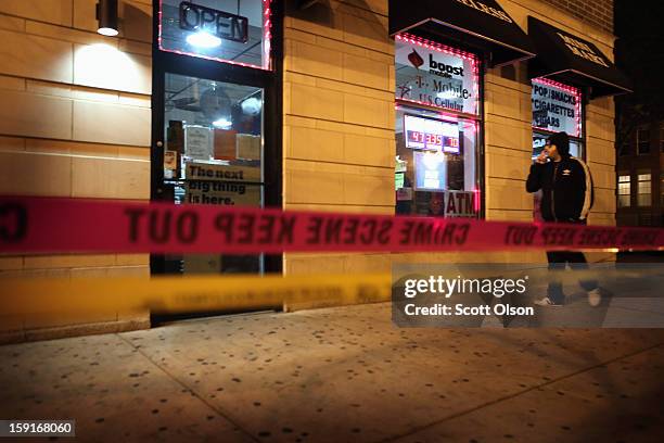 Store owner smokes a cigarette outside his store where two men were shot in the Old Town neighborhood on January 8, 2013 in Chicago, Illinois....