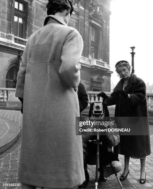 Richard Avedon during a shooting session with Carmel Snow editor of the American edition of Harper's Bazaar and a Dior model in front of the Opera de...