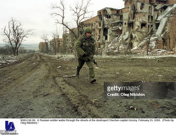 Russian soldier walks through the streets of the destroyed Chechen capital Grozny, February 25, 2000.