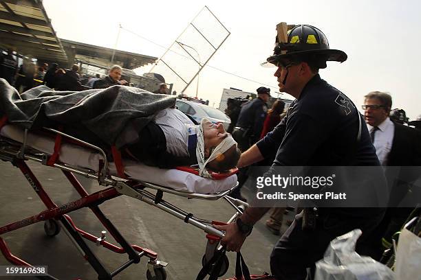An injured person is carried to a waiting ambulance following an early morning ferry accident during rush hour in Lower Manhattan on January 9, 2013...