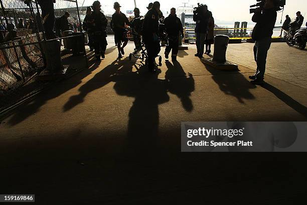 An injured person is carried to a waiting ambulance following an early morning ferry accident during rush hour in Lower Manhattan on January 9, 2013...