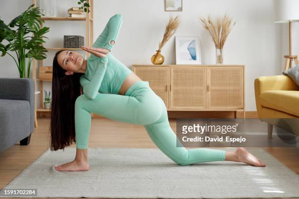 athlete woman doing yoga exercise in the living room at home. - yoga rug photos et images de collection