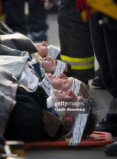 New York Fire Department firefighters prepare to take away injured ferry commuters on stretchers in New York, U.S., on Wednesday, Jan. 9, 2013. A...