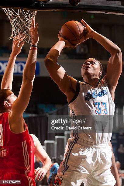 Daniel Orton of the Tulsa 66ers drives to the basket guarded by Chris Ayer of the Maine Red Claws during the 2013 NBA D-League Showcase on January 7,...