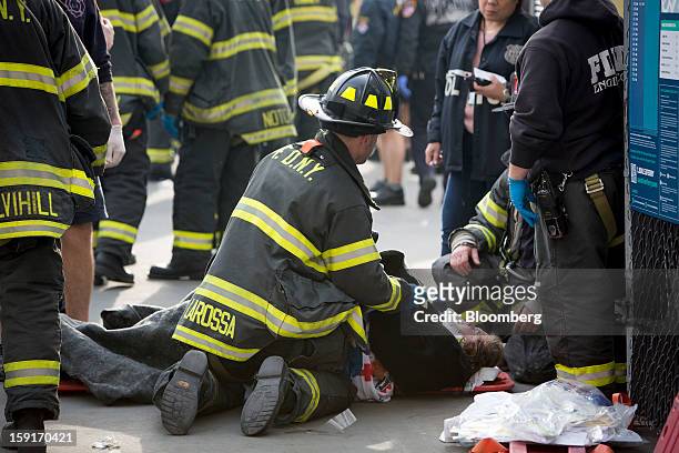 New York Fire Department firefighter tends to an injured ferry commuter on a stretcher in New York, U.S., on Wednesday, Jan. 9, 2013. A Seastreak...
