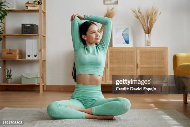 athlete woman stretching after exercising at home. - strekken stockfoto's en -beelden