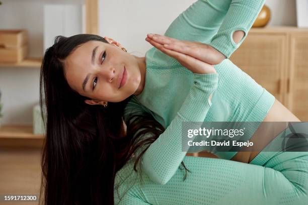 close-up of an athlete woman doing yoga exercise in the living room at home. - yoga rug photos et images de collection