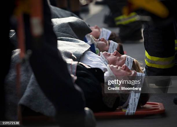 New York Fire Department firefighters prepare to take away injured ferry commuters on stretchers in New York, U.S., on Wednesday, Jan. 9, 2013. A...