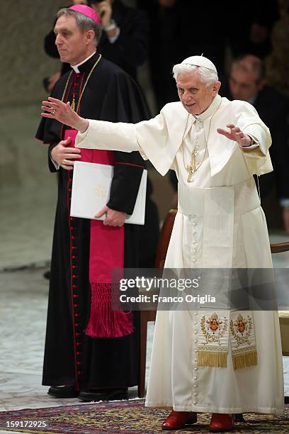 Pope Benedict XVI , flanked by his personal secretary Georg Gaenswein , waves to the faithful gathered at the Paul VI Hall during his weekly audience...