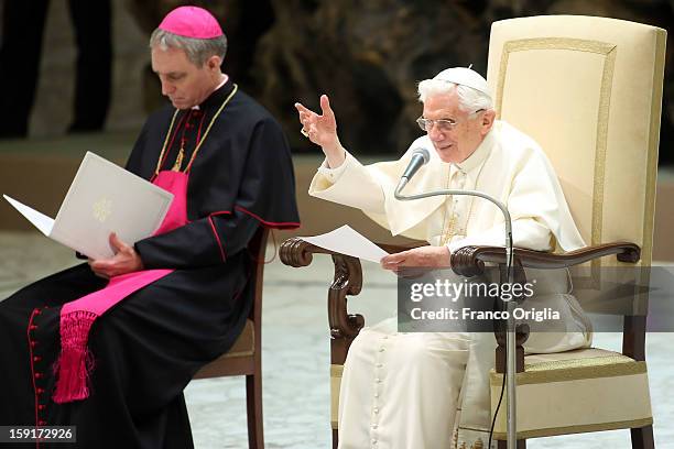 Pope Benedict XVI , flanked by his personal secretary Georg Gaenswein , waves to the faithful gathered at the Paul VI Hall during his weekly audience...