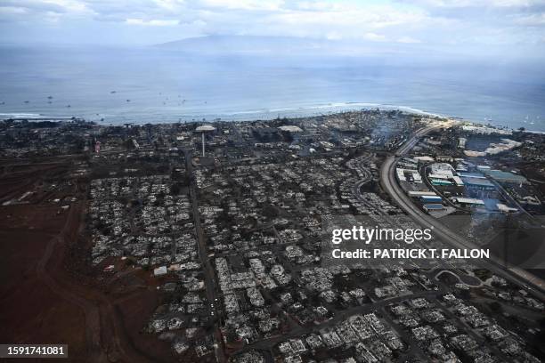 An aerial image taken on August 10, 2023 shows destroyed homes and buildings burned to the ground in Lahaina along the Pacific Ocean in the aftermath...