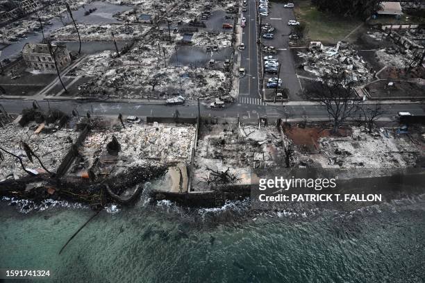 An aerial image taken on August 10, 2023 shows destroyed homes and buildings burned to the ground in Lahaina along the Pacific Ocean in the aftermath...