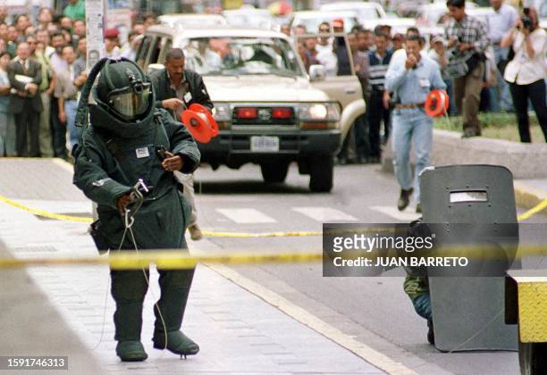 An expert of explosives of DISIP approaches the supposed bomb to deactivate it in front of the National Congress of Venezuela in Caracas 15 June,...