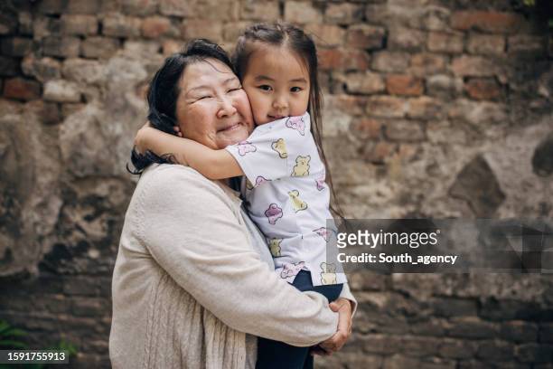 grandma holding her granddaughter - mongolian women 個照片及圖片檔