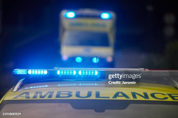two ambulances of emergency medical service on road - ambulance stock pictures, royalty-free photos & images
