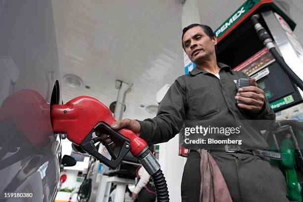 An attendant fills the tank of a vehicle with gasoline at a Pemex station in Mexico City, Mexico, on Tuesday, Jan. 8, 2013. Mexico’s government is...