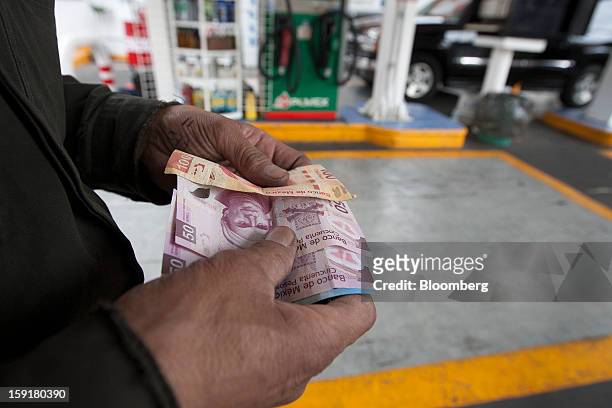 An attendant counts money at a Pemex station in Mexico City, Mexico, on Tuesday, Jan. 8, 2013. Mexico’s government is speeding up the removal of...