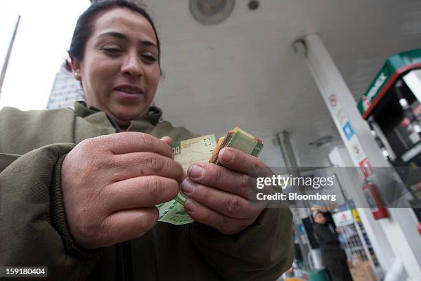 An attendant counts money at a Pemex station in Mexico City, Mexico, on Tuesday, Jan. 8, 2013. Mexico’s government is speeding up the removal of...