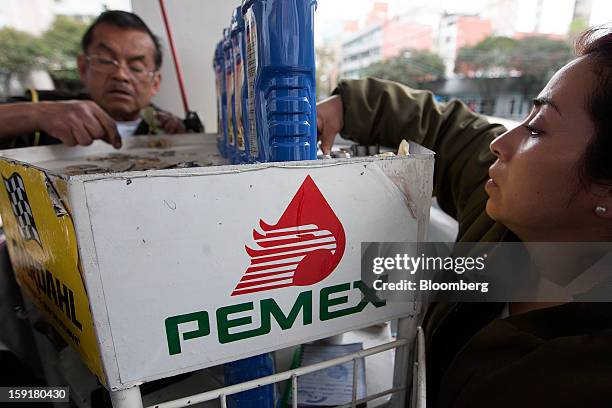 Attendants make change at a Pemex station in Mexico City, Mexico, on Tuesday, Jan. 8, 2013. Mexico’s government is speeding up the removal of...