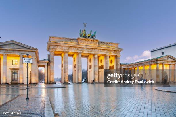 porta di brandeburgo a berlino, germania di notte con terreno bagnato e cielo blu. - berlino germania foto e immagini stock