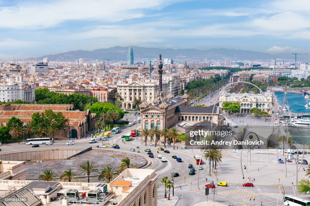 Panoramic view of Barcelona from above with landmarks and coastline.