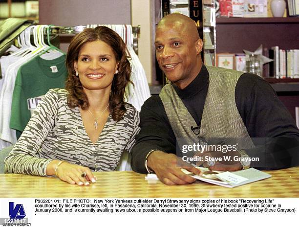 New York Yankees outfielder Darryl Strawberry signs copies of his book "Recovering Life" coauthored by his wife Charisse, left, in Pasadena,...