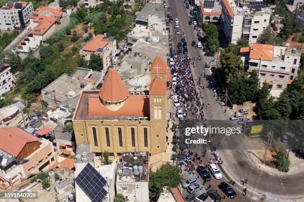 An aerial view shows mourners gathering outside the Saint Anthony church in the town of Kahale, east of Beirut, on August 11, 2023 during the funeral...