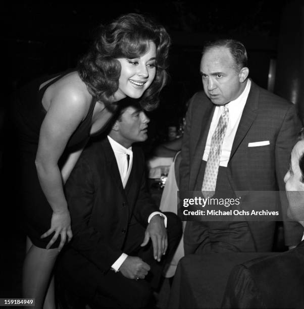 Actress Sherry Jackson chats with an unidentified man as LA gangster Mickey Cohen looks on at a nightclub in 1959 in Los Angeles, California.