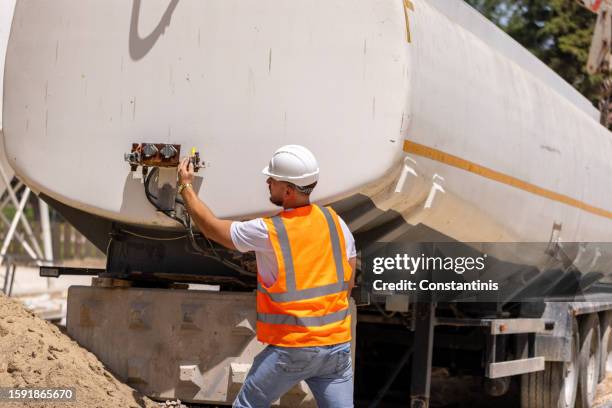 le travailleur de la construction contrôle la pression dans le réservoir - manomètre photos et images de collection