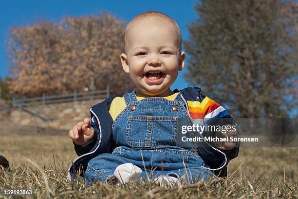 smiling baby in overalls - michael virtue stock pictures, royalty-free photos & images