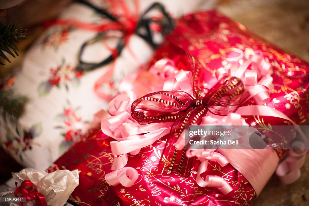 Christmas present wrapped in pink and red ribbons