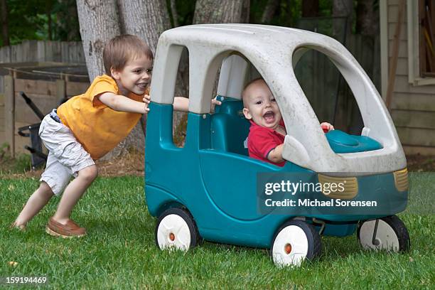 boys playing in a toy car - michael virtue stock pictures, royalty-free photos & images